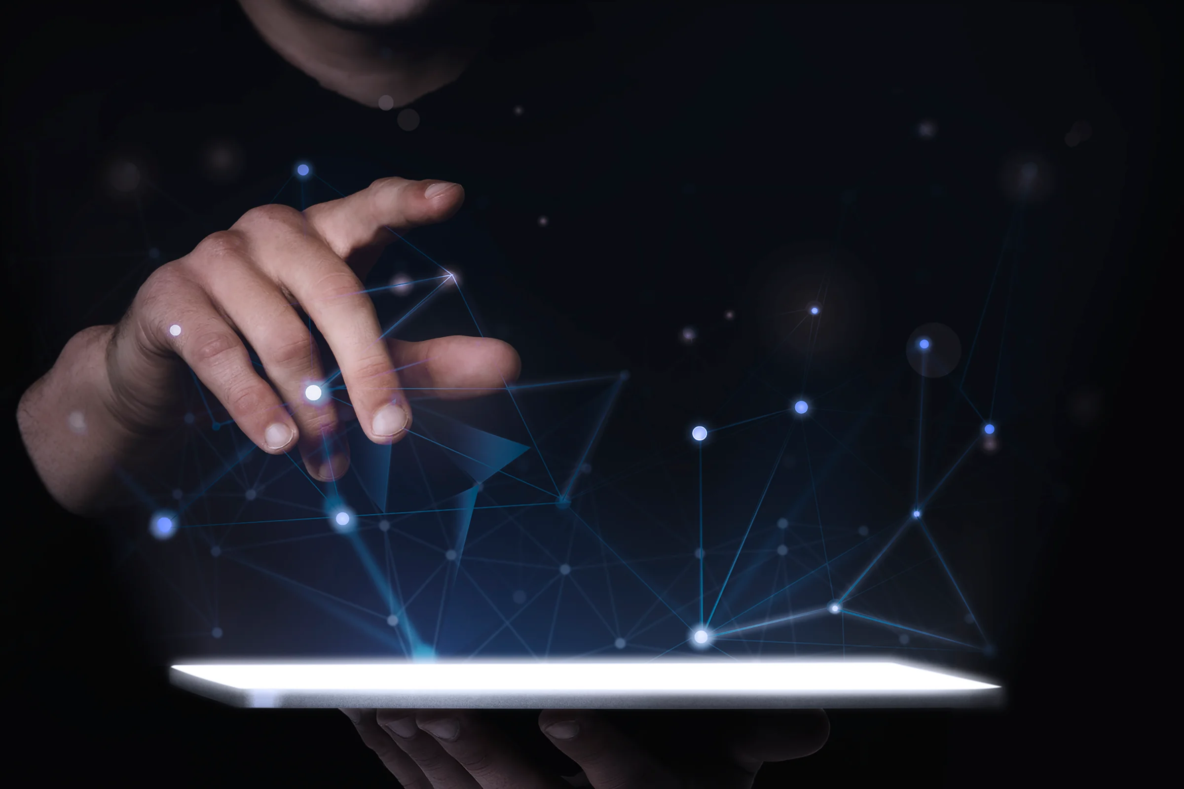 Mão tocando um tablet de onde saem linhas de rede luminosas